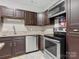 Modern kitchen featuring stainless steel appliances, tile backsplash, and dark wood cabinets at 9473 Kings Falls Dr, Charlotte, NC 28210