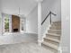 Open-concept living room features a brick fireplace, stairs, and modern flooring at 9473 Kings Falls Dr, Charlotte, NC 28210