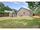 A grassy backyard features a storage shed and wooden privacy fence at 9716 Psalms St, Cornelius, NC 28031