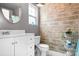 Stylish bathroom with wood accent wall, round mirror, and sleek vanity at 9716 Psalms St, Cornelius, NC 28031