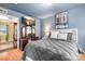 Main bedroom features an accent wall, wood floors, TV and adjacent closet at 9716 Psalms St, Cornelius, NC 28031