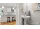 Powder room with pedestal sink and modern fixtures, adjacent to open kitchen at 1011 Westbrook Dr # A, Charlotte, NC 28202