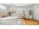 Bedroom with hardwood floors, white walls, area rug and large window at 1011 Westbrook Dr # A, Charlotte, NC 28202
