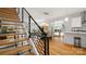 Open concept dining and living area with modern staircase, hardwood floors and natural light at 1011 Westbrook Dr # A, Charlotte, NC 28202