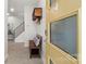 Inviting entryway with a yellow door, coat rack, bench, and staircase at 1011 Westbrook Dr # A, Charlotte, NC 28202