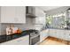 Modern kitchen with stainless steel appliances, granite countertops, and white cabinetry at 1011 Westbrook Dr # A, Charlotte, NC 28202