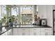 Bright kitchen featuring white cabinets, granite countertops, and a window with plants at 1011 Westbrook Dr # A, Charlotte, NC 28202