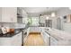 Bright, all-white kitchen featuring an island with marble countertop, stainless steel appliances, and hardwood floors at 1011 Westbrook Dr # A, Charlotte, NC 28202