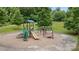 Community playground featuring a slide, climbing structure, and swings surrounded by lush greenery at 1011 Westbrook Dr # A, Charlotte, NC 28202
