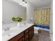 Bright bathroom featuring a double vanity, a bathtub, and lemon-themed shower curtain at 1019 Beacon Ave, Monroe, NC 28110