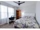Bright bedroom features a ceiling fan, large window, white desk and a printed comforter at 1019 Beacon Ave, Monroe, NC 28110