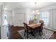 Dining room with chandelier, dark wood floors and decorative rug next to window with curtains at 1019 Beacon Ave, Monroe, NC 28110