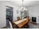 Formal dining room featuring a decorative chandelier, wooden table, and view into kitchen at 1019 Beacon Ave, Monroe, NC 28110