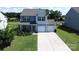 Two-story home with two-car garage, light blue siding, green grass, and well-maintained landscaping at 1019 Beacon Ave, Monroe, NC 28110
