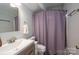 Bathroom featuring a single sink vanity with modern fixtures and a shower with lavender curtain at 10925 Lassen Ct, Charlotte, NC 28214