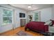 Bright bedroom featuring a large window, wood floors, and a modern ceiling fan at 10925 Lassen Ct, Charlotte, NC 28214