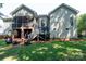 The home's backyard features lush green grass and mature trees, with a screened porch and stairs leading down at 126 Doyle Farm Ln, Mooresville, NC 28115