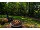Cozy backyard with a fire pit, an Adirondack chair, and flowers against a backdrop of lush greenery at 126 Doyle Farm Ln, Mooresville, NC 28115