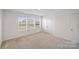 A bright bedroom with three windows and neutral carpet at 128 Cherry Birch St, Mooresville, NC 28117