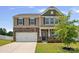 Charming two-story home featuring stone accents, a two-car garage, and a well-manicured front lawn at 128 Cherry Birch St, Mooresville, NC 28117