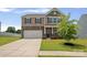 Charming two-story home showcasing stone accents, a front-facing garage, and a well-kept lawn at 128 Cherry Birch St, Mooresville, NC 28117