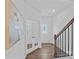 Bright hallway featuring hardwood floors, white trim, a staircase, and a glass paneled door at 128 Cherry Birch St, Mooresville, NC 28117