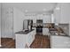 Modern kitchen with stainless steel appliances, gray backsplash, granite counters, white cabinets and a center island at 128 Cherry Birch St, Mooresville, NC 28117