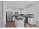 Modern kitchen features stainless steel appliances, granite counters, an island, and sleek white cabinets at 128 Cherry Birch St, Mooresville, NC 28117