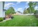 Large backyard with a wooden deck, grill, green grass, and partially fenced yard at 1308 Stonewyck Dr, Salisbury, NC 28146