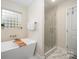 Spa-like bathroom with freestanding tub, glass block window, and separate glass enclosed shower at 1308 Stonewyck Dr, Salisbury, NC 28146