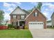 Charming two-story brick home featuring an attached two-car garage, well-manicured lawn, and a welcoming front garden at 1308 Stonewyck Dr, Salisbury, NC 28146
