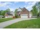 Two-story brick home with attached garage, well-manicured lawn and long concrete driveway at 1308 Stonewyck Dr, Salisbury, NC 28146
