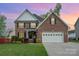 Charming two-story brick home featuring an attached two-car garage, well-manicured lawn, and a welcoming front garden at 1308 Stonewyck Dr, Salisbury, NC 28146