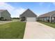 View of a well-maintained backyard and a two-car garage with a concrete driveway at 146 Kerri Dawn Ln, Locust, NC 28097