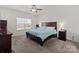Well-lit bedroom with carpet, ceiling fan, dresser, and queen-size bed facing a large window at 146 Kerri Dawn Ln, Locust, NC 28097