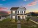 Charming two-story home with a welcoming front porch and well-manicured landscaping at sunset at 146 Kerri Dawn Ln, Locust, NC 28097
