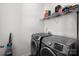 Practical laundry room with modern washer and dryer units and storage shelves at 146 Kerri Dawn Ln, Locust, NC 28097