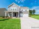 Two-story home with stone and gray siding, well-manicured lawn, and a two-car garage at 1531 River Cane St, Edgemoor, SC 29712