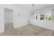 Dining area with decorative light fixture and view to the living room fireplace at 1604 Sharon W Rd, Charlotte, NC 28210