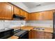 Kitchen featuring wooden cabinets, stainless steel sink, and black appliances at 1604 Sharon W Rd, Charlotte, NC 28210