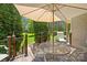 Back deck featuring a metal table and chairs, perfect for enjoying the outdoors and views of the lush backyard at 168 Blue Ridge Trl, Mooresville, NC 28117