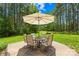 Back patio featuring an umbrella and outdoor seating, perfect for enjoying the serene backyard and nature at 168 Blue Ridge Trl, Mooresville, NC 28117