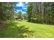Expansive backyard featuring a lush lawn and mature trees, offering privacy and a serene outdoor setting at 168 Blue Ridge Trl, Mooresville, NC 28117