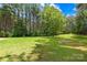 Large backyard with lush green grass and mature trees, perfect for outdoor activities and relaxation at 168 Blue Ridge Trl, Mooresville, NC 28117