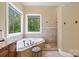 This bright bathroom offers a garden tub with scenic views of the surrounding nature at 168 Blue Ridge Trl, Mooresville, NC 28117