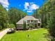 Beautiful stone and stucco home with lush landscaping and a circular driveway nestled among mature trees at 168 Blue Ridge Trl, Mooresville, NC 28117