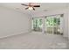 Bright bedroom with neutral walls, ceiling fan, and sliding glass doors to the screened-in porch at 17513 Hawks View Dr, Fort Mill, SC 29707
