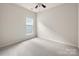 A bright, neutral bedroom features a ceiling fan and a window allowing lots of natural light at 17513 Hawks View Dr, Fort Mill, SC 29707
