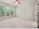 A bright bedroom featuring carpeting and windows, providing natural light and backyard views at 17513 Hawks View Dr, Fort Mill, SC 29707