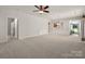 Open-concept living room with plush carpeting, a ceiling fan, and an open view to the kitchen at 17513 Hawks View Dr, Fort Mill, SC 29707
